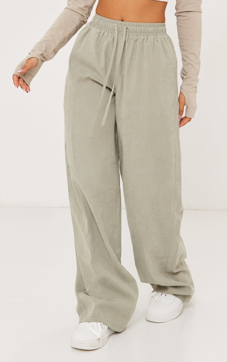 https://cdn-img.prettylittlething.com/c/d/7/d/cd7d7df612824c0cf97a3329ee56af55550b3c5e_CNF8694_2_petite_pale_green_peach_skin_cargo_trousers.jpg